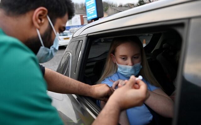 A woman receives a COVID-19 vaccine at a drive-thru NHS vaccination center in Blackburn, north-west England, on January 17, 2022, as the Omicron coronavirus variant spreads in the country. (Paul Ellis/AFP) A woman receives a COVID-19 vaccine at a drive-thru NHS vaccination center in Blackburn, north-west England, on January 17, 2022, as the Omicron coronavirus variant spreads in the country. (Paul Ellis/AFP)