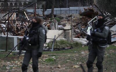 Israeli forces stand by the ruins of a Palestinian house demolished in Sheikh Jarrah neighborhood of Jerusalem on January 19, 2022 (Ahmad Gharabli/AFP)