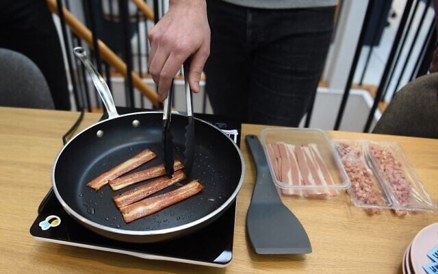French startup 'La Vie' co-founder and CEO Nicolas Schweitzer cooks their veggie recipe bacon sticks at their headquarters in Paris on January 7, 2022. (Photo by Eric Piermont/AFP) French startup 'La Vie' co-founder and CEO Nicolas Schweitzer cooks their veggie recipe bacon sticks at their headquarters in Paris on January 7, 2022. (Photo by Eric Piermont/AFP)