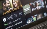 This picture taken on January 23, 2022, in Cairo shows a laptop displaying a scene from the Netflix-produced pan-Arab film 'Ashab wala Aaz' depicting Lebanese actors Adel Karam and Diamand Bou Abboud. (Khaled Desouki/AFP)