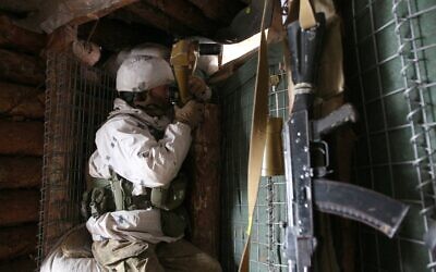 Illustrative: A Ukrainian Military Forces serviceman watches through spyglass in a dugout on the frontline with Russia-backed separatists near Gorlivka, Donetsk region on January 23, 2022. (Anatolii STEPANOV / AFP) Illustrative: A Ukrainian Military Forces serviceman watches through spyglass in a dugout on the frontline with Russia-backed separatists near Gorlivka, Donetsk region on January 23, 2022. (Anatolii STEPANOV / AFP)