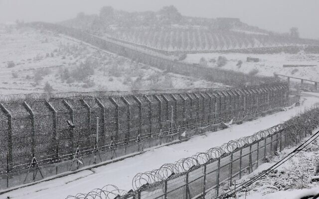 The border fence with Syria in the Golan Heights during snowfall on January 26, 2022. (JALAA MAREY / AFP) The border fence with Syria in the Golan Heights during snowfall on January 26, 2022. (JALAA MAREY / AFP)