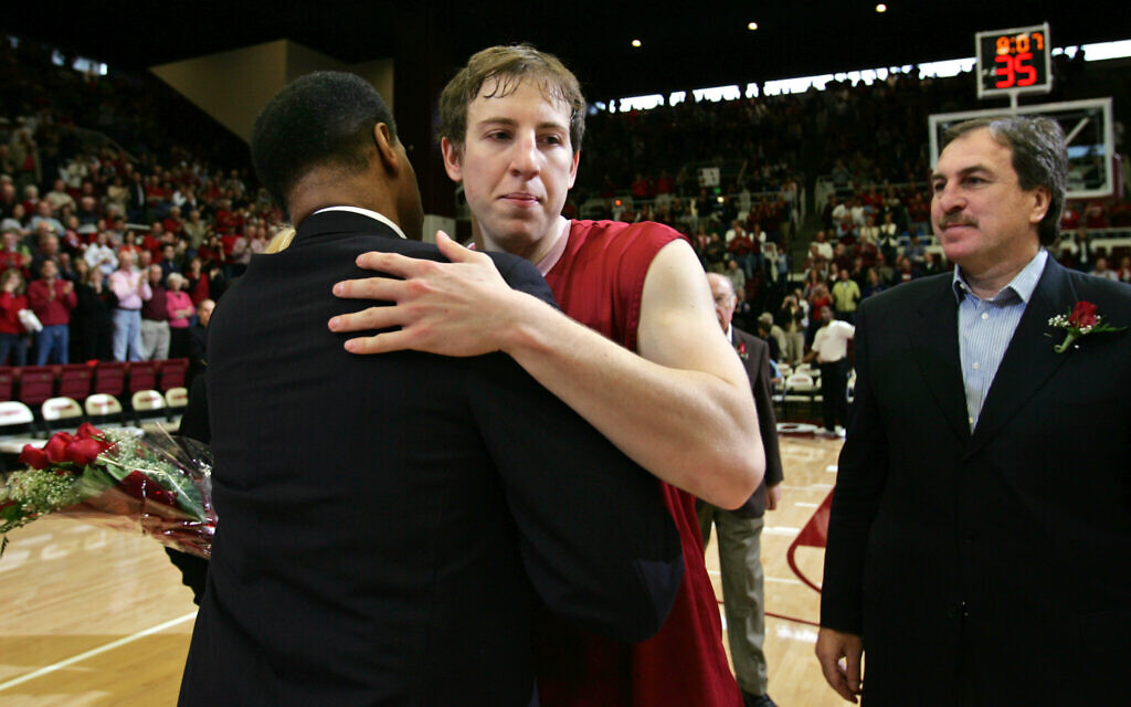 Stanford guard Dan Grunfeld, center, hugs head coach Trent Johnson, left, after receiving flowers during a Senior Day presentation as Grunfeld's father, Ernie Grunfeld, right, looks on before Stanford's NCAA basketball game against UCLA, March 4, 2006 in Stanford, California. (AP Photo/Paul Sakuma)