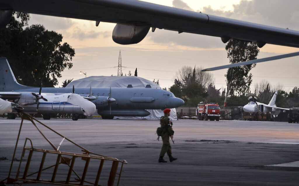 A Russian military police officer stands guard at the Russian air base in Hemeimeem, Syria, with an Il-20 electronic intelligence plane of the Russian air force is in the background, March 4, 2016. (AP)