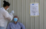 A health worker carries out a COVID-19 test of a resident of Larnaca, a resort town in southern coast of Cyprus, on Sept. 28, 2020 (AP Photo/Petros Karadjias)