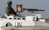 A UN peacekeeping soldier sits on a tank at a road that links to a UNIFIL base where the Lebanese and Israeli delegations meet, in Naqoura town, Lebanon, on Tuesday, May 4, 2021. (AP Photo/Hussein Malla)
