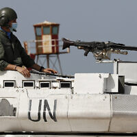 A UN peacekeeping soldier sits on a tank at a road that links to a UNIFIL base where the Lebanese and Israeli delegations meet, in Naqoura town, Lebanon, on Tuesday, May 4, 2021. (AP Photo/Hussein Malla)