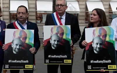 French officials hold portraits of Ramy Shaath during a rally near the Egyptian embassy in Paris, June 23, 2021. (AP Photo/ Lewis Joly)