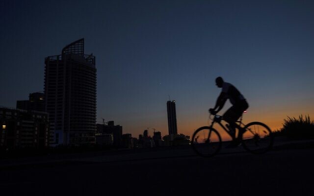 A man rides his bike along the seaside promenade as the capital city remains in darkness during a power outage, in Beirut, Lebanon, on Thursday, August 19, 2021. (AP Photo/ Hassan Ammar) A man rides his bike along the seaside promenade as the capital city remains in darkness during a power outage, in Beirut, Lebanon, on Thursday, August 19, 2021. (AP Photo/ Hassan Ammar)