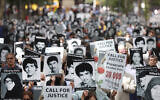 Protesters hold photos of individuals they say are political prisoners killed in 1988 during a rally to denounce Iranian President Ebrahim Raisi near United Nations headquarters, Sept. 21, 2021 (AP Photo/Jason DeCrow)
