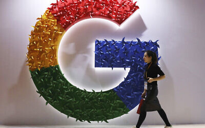 A woman walks past the logo for Google at the China International Import Expo in Shanghai, on Monday, November 5, 2018. (AP/Ng Han Guan, File)