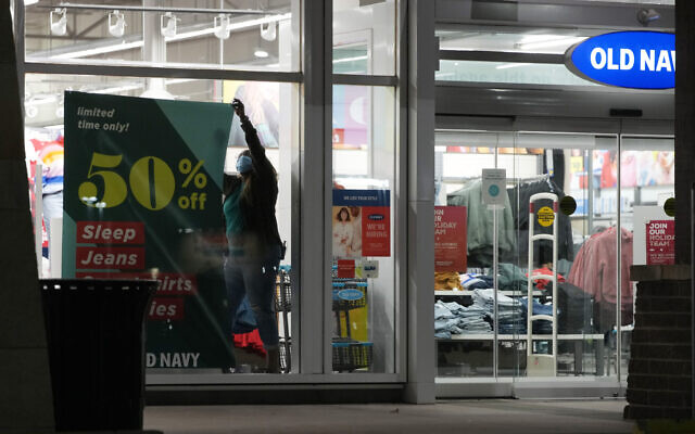 A worker hangs a sign to advertise discounted prices in the front window of an Old Navy store after doors opened at 5 a.m. Friday, Nov. 26, 2021, in Lone Tree, Colo. (AP Photo/David Zalubowski) A worker hangs a sign to advertise discounted prices in the front window of an Old Navy store after doors opened at 5 a.m. Friday, Nov. 26, 2021, in Lone Tree, Colo. (AP Photo/David Zalubowski)