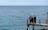 Nadine Kalache Maalouf (center), Celine Elbacha, and Elbacha's daughter Morgane (right) stand on a deck at the seaside in eastern coastal resort of Paralimni, Cyprus, on December 22, 2021. (AP Photo/Petros Karadjias)