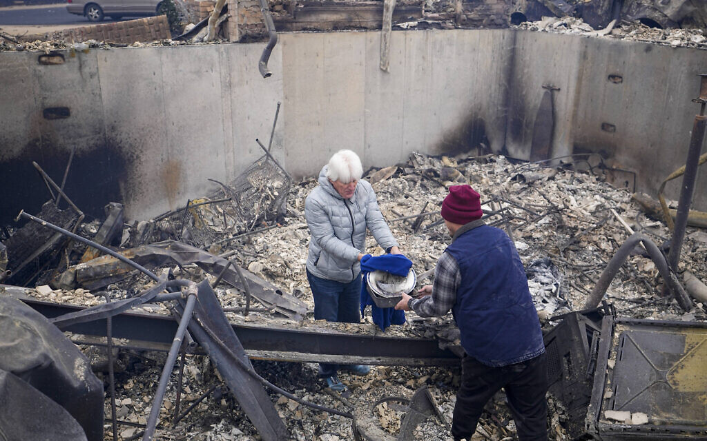 Illustrative: A man finds a couple of plates as he looks through the rubble of his fire-damaged home after the Marshall Wildfire in Louisville, Colorado, December 31, 2021. (AP Photo/Jack Dempsey) Illustrative: A man finds a couple of plates as he looks through the rubble of his fire-damaged home after the Marshall Wildfire in Louisville, Colorado, December 31, 2021. (AP Photo/Jack Dempsey)