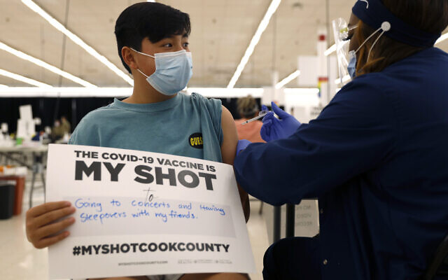 Illustrative: Lucas Kittikamron-Mora, 13, holds a sign in support of COVID-19 vaccinations as he receives his first Pfizer vaccination at the Cook County Public Health Department, May 13, 2021, in Des Plaines, Illinois. (AP Photo/ Shafkat Anowar, file) Illustrative: Lucas Kittikamron-Mora, 13, holds a sign in support of COVID-19 vaccinations as he receives his first Pfizer vaccination at the Cook County Public Health Department, May 13, 2021, in Des Plaines, Illinois. (AP Photo/ Shafkat Anowar, file)