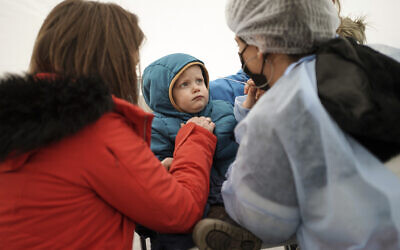 A health worker speaks tests a toddler for COVID-19, in Albigny-sur-Saone, outside Lyon, central France, on Tuesday, January 4, 2022. (AP Photo/Laurent Cipriani) A health worker speaks tests a toddler for COVID-19, in Albigny-sur-Saone, outside Lyon, central France, on Tuesday, January 4, 2022. (AP Photo/Laurent Cipriani)