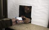 A Palestinian man hands over his temporary ID to a civil affairs employee to get his officially approved register letter, in Gaza City, January 3, 2022. (AP Photo/ Khalil Hamra)