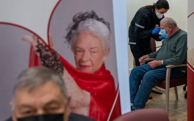 A man receives a fourth Pfizer-BioNTech COVID-19 vaccine from a Magen David Adom national emergency service volunteer, at a private nursing home, in Netanya, Israel, on Wednesday, January 5, 2022. (AP/Ariel Schalit) A man receives a fourth Pfizer-BioNTech COVID-19 vaccine from a Magen David Adom national emergency service volunteer, at a private nursing home, in Netanya, Israel, on Wednesday, January 5, 2022. (AP/Ariel Schalit)