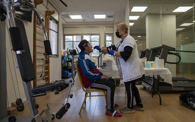 A man gets a PCR coronavirus test at a private nursing home in Netanya, Israel, January 5, 2022. (Ariel Schalit/AP)