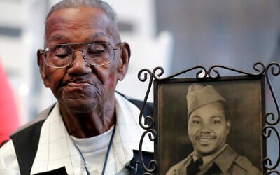 World War II veteran Lawrence Brooks holds a photo of him taken in 1943, as he celebrates his 110th birthday at the National World War II Museum in New Orleans, on September 12, 2019. (AP Photo/Gerald Herbert, File)