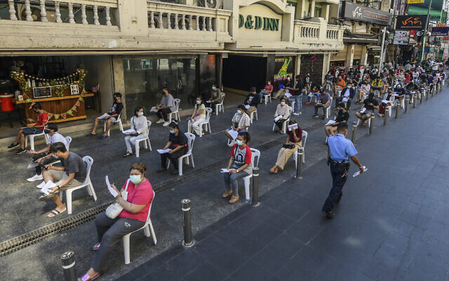 Workers wear face masks and practice social distancing while they wait to be tested for the coronavirus at Khaosan road in Bangkok, Thailand, on January 6, 2022. (Vichan Poti/AP) Workers wear face masks and practice social distancing while they wait to be tested for the coronavirus at Khaosan road in Bangkok, Thailand, on January 6, 2022. (Vichan Poti/AP)