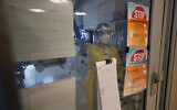 Registered nurse Morgan Flynn works inside a patient's room in the COVID-19 Intensive Care Unit at Dartmouth-Hitchcock Medical Center, in Lebanon, New Hampshire, January 3, 2022. (AP Photo/Steven Senne)