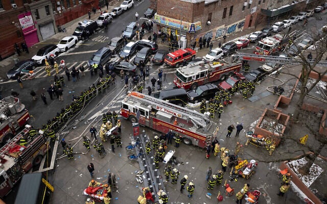 Firefighters work outside an apartment building after a fire in the Bronx, January 9, 2022, in New York. (AP Photo/Yuki Iwamura) Firefighters work outside an apartment building after a fire in the Bronx, January 9, 2022, in New York. (AP Photo/Yuki Iwamura)