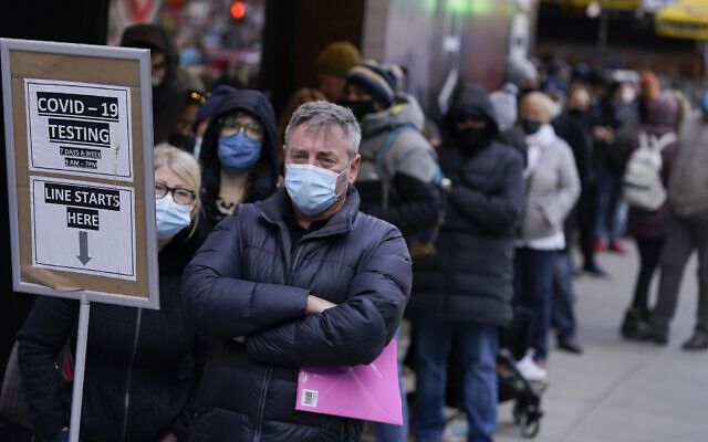 People wait in line at a COVID-19 testing site in Times Square, New York, on December 13, 2021. (AP Photo/Seth Wenig)