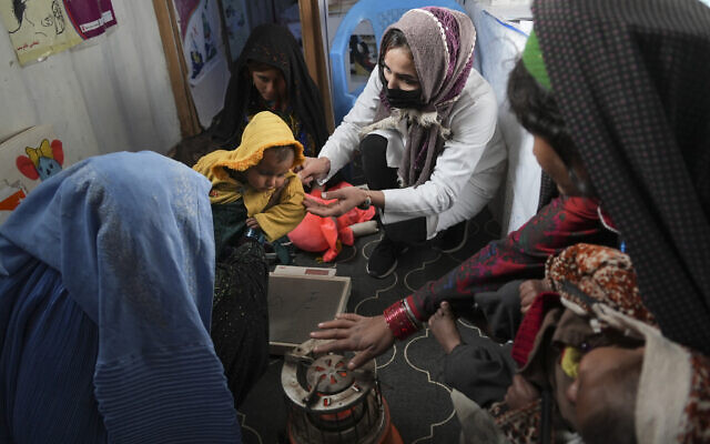 A nurse checks the weight of a child in a makeshift clinic organized by World Vision, at a settlement near Herat, Afghanistan, on December 16, 2021. (AP Photo/Mstyslav Chernov, File) A nurse checks the weight of a child in a makeshift clinic organized by World Vision, at a settlement near Herat, Afghanistan, on December 16, 2021. (AP Photo/Mstyslav Chernov, File)