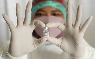 As part of the global race to vaccinate against COVID-19, a medical worker at South Tangerang Regional General Hospital in Tangerang, Indonesia, holds a vaccine vial the she is using to administer third doses on, Jan. 12, 2022. (AP Photo/Tatan Syuflana) As part of the global race to vaccinate against COVID-19, a medical worker at South Tangerang Regional General Hospital in Tangerang, Indonesia, holds a vaccine vial the she is using to administer third doses on, Jan. 12, 2022. (AP Photo/Tatan Syuflana)