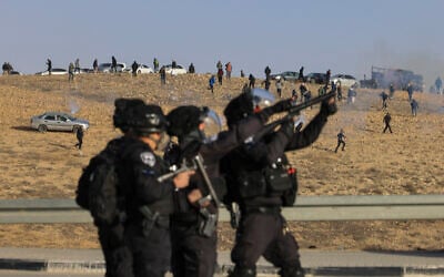 Israeli security forces fire tear gas at Bedouin demonstrators following a protest against a forestation project by the Jewish National Fund near the Bedouin village of Sa'we al-Atrash in the Negev Desert, southern Israel, January 13, 2022. (AP Photo/Tsafrir Abayov)