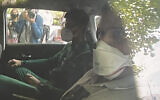 Novak Djokovic sits in the back of car arriving at an immigration detention hotel in Melbourne, Australia, January 15, 2022. (Channel 9 via AP)
