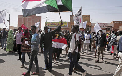 People hold flags during a protest in Khartoum, Sudan, January 17, 2022. Thousands of people took to the streets to protest the 2021 coup that has plunged the country into grinding deadlock. (AP Photo/Marwan Ali)