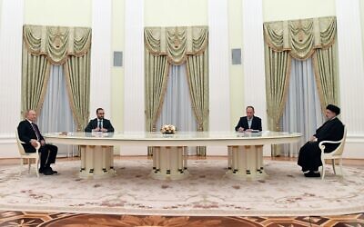 Russian President Vladimir Putin (left) and Iranian President Ebrahim Raisi talk to each other during their meeting in the Kremlin in Moscow, Russia, on Wednesday, January 19, 2022. (Pavel Bednyakov/Sputnik, Kremlin Pool Photo via AP)