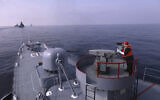 In this photo provided Friday, January 21, 2022 by the Iranian Army, an Iranian army member fires a weapon during a joint naval drill of Iran, Russia and China in the Indian Ocean. (Iranian Army via AP)