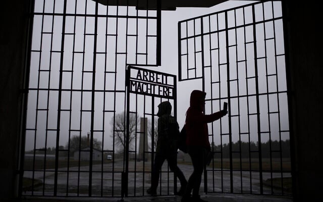 People take photos as they enter the Sachsenhausen Nazi death camp through the gate with the phrase 'Arbeit macht frei' (work sets you free), in Oranienburg, about 30 kilometers (18 miles) north of Berlin, Germany, Tuesday, January 25, 2022. (AP/Markus Schreiber) People take photos as they enter the Sachsenhausen Nazi death camp through the gate with the phrase 'Arbeit macht frei' (work sets you free), in Oranienburg, about 30 kilometers (18 miles) north of Berlin, Germany, Tuesday, January 25, 2022. (AP/Markus Schreiber)