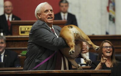 West Virginia Gov. Jim Justice holds up his dog Babydog's rear end as a message to people who've doubted the state as he comes to the end of his State of the State speech in the House chambers, Thursday, Jan. 27, 2022, in Charleston, W.Va. (Chris Dorst/Charleston Gazette-Mail via AP)