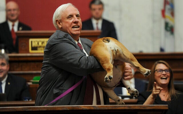 West Virginia Gov. Jim Justice holds up his dog Babydog's rear end as a message to people who've doubted the state as he comes to the end of his State of the State speech in the House chambers, Thursday, Jan. 27, 2022, in Charleston, W.Va. (Chris Dorst/Charleston Gazette-Mail via AP)