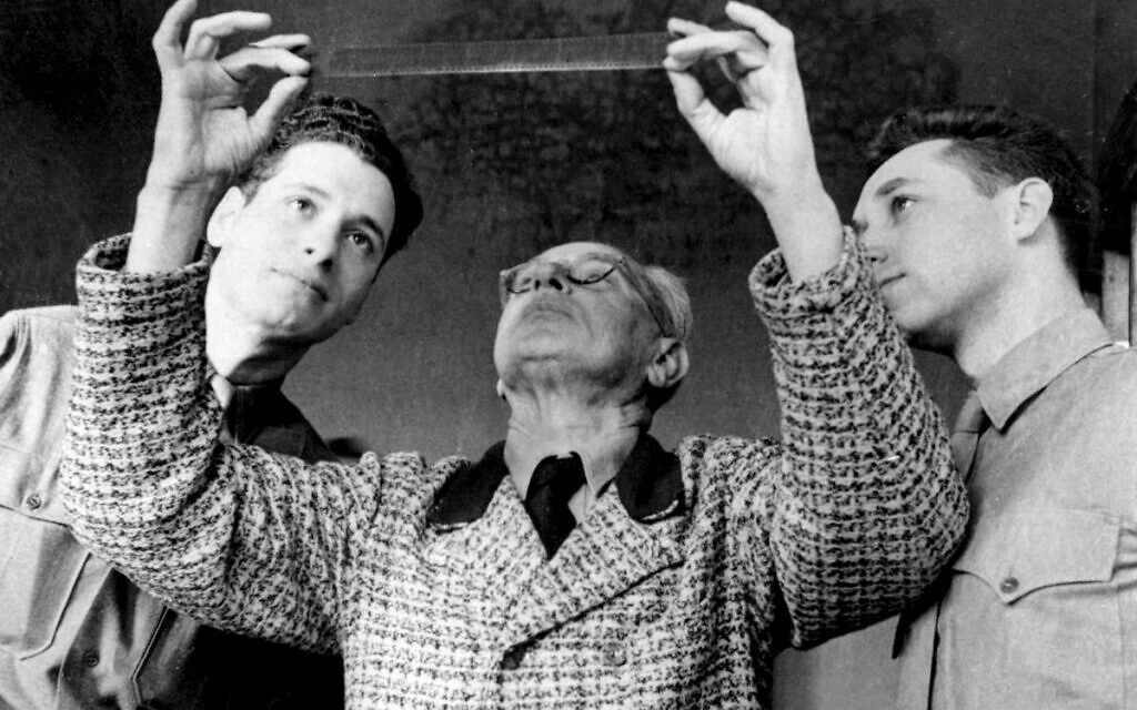 'Nuremberg' filmmaker Stuart Schulberg, right, looks at film with Hitler's photographer Heinrich Hoffmann, center, in this still from the new documentary 'The Lost Film of Nuremberg' by Sandra Schulberg. (Courtesy/ New York Jewish Film Festival)
