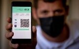 A man displays the Green Pass on his cellphone in Jerusalem, October 4, 2021. (Yonatan Sindel/Flash90)