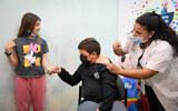 An Israeli child receives his second shot of the COVID-19 vaccine at Clalit vaccine center for children in Kfar Saba, December 13, 2021. (Flash90)