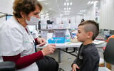 A child receives a COVID-19 vaccine at a Clalit vaccination center in Katzrin, Golan Heights, on December 16, 2021. (Michael Giladi/Flash90)