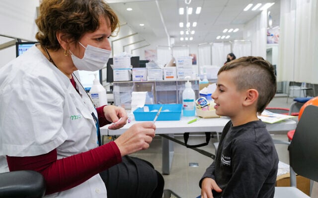 A child receives a COVID-19 vaccine at a Clalit vaccination center in Katzrin, Golan Heights, on December 16, 2021. (Michael Giladi/Flash90)