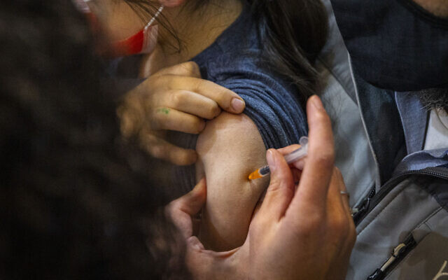 Illustrative -- Child receives a dose of the COVID-19 vaccine in Jerusalem on December 21, 2021 (Olivier Fitoussi/Flash90) Illustrative -- Child receives a dose of the COVID-19 vaccine in Jerusalem on December 21, 2021 (Olivier Fitoussi/Flash90)