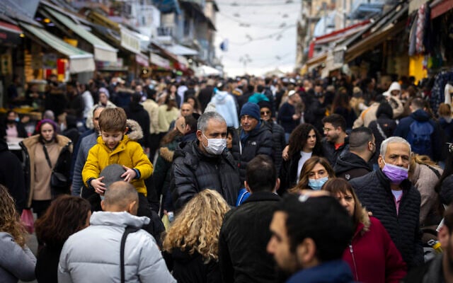 People shop at the Mahane Yehuda Market in Jerusalem on December 24, 2021. (Olivier Fitoussi/Flash90) People shop at the Mahane Yehuda Market in Jerusalem on December 24, 2021. (Olivier Fitoussi/Flash90)