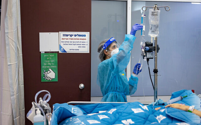 A member of Hadassah Medical Center's staff cares for a coronavirus patient on December 27, 2021. (Olivier Fitoussi/Flash90)
