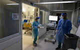 Hadassah Ein Kerem Hospital staff wear safety gear as they work in a coronavirus ward on December 27, 2021. (Olivier Fitoussi/Flash90)