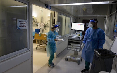 Hadassah Ein Kerem Hospital staff wear safety gear as they work in a coronavirus ward on December 27, 2021. (Olivier Fitoussi/Flash90)