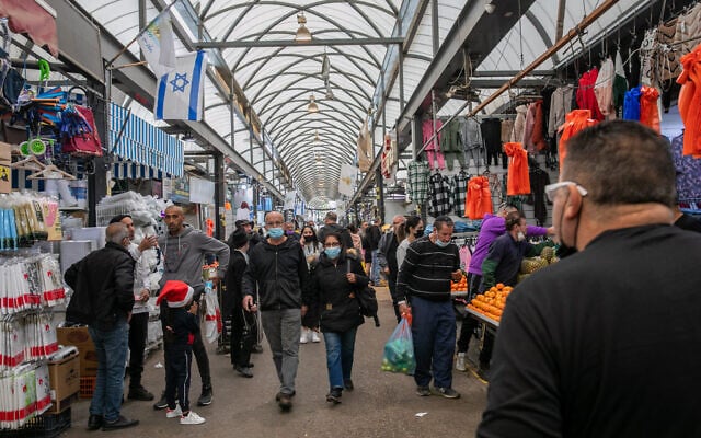 People shop at the market in the central town of Ramle, on December 31, 2021.(Yossi Aloni/Flash90) People shop at the market in the central town of Ramle, on December 31, 2021.(Yossi Aloni/Flash90)