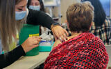 A woman receives a fourth dose of the COVID-19 vaccine, at a medical center in Ashkelon, on January 3, 2022. (Flash90)
